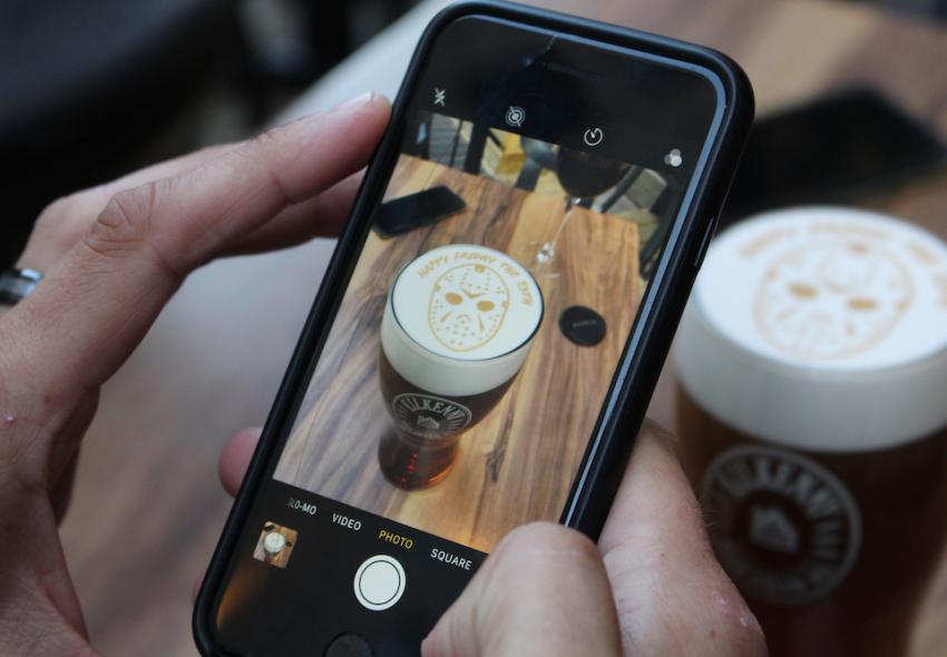 A person taking a photo of beer