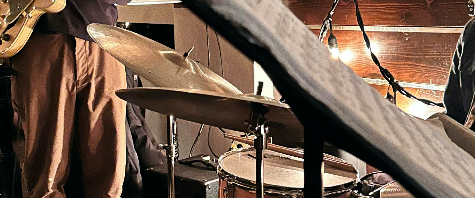 Gabe Mink playing guitar beside a drummer.