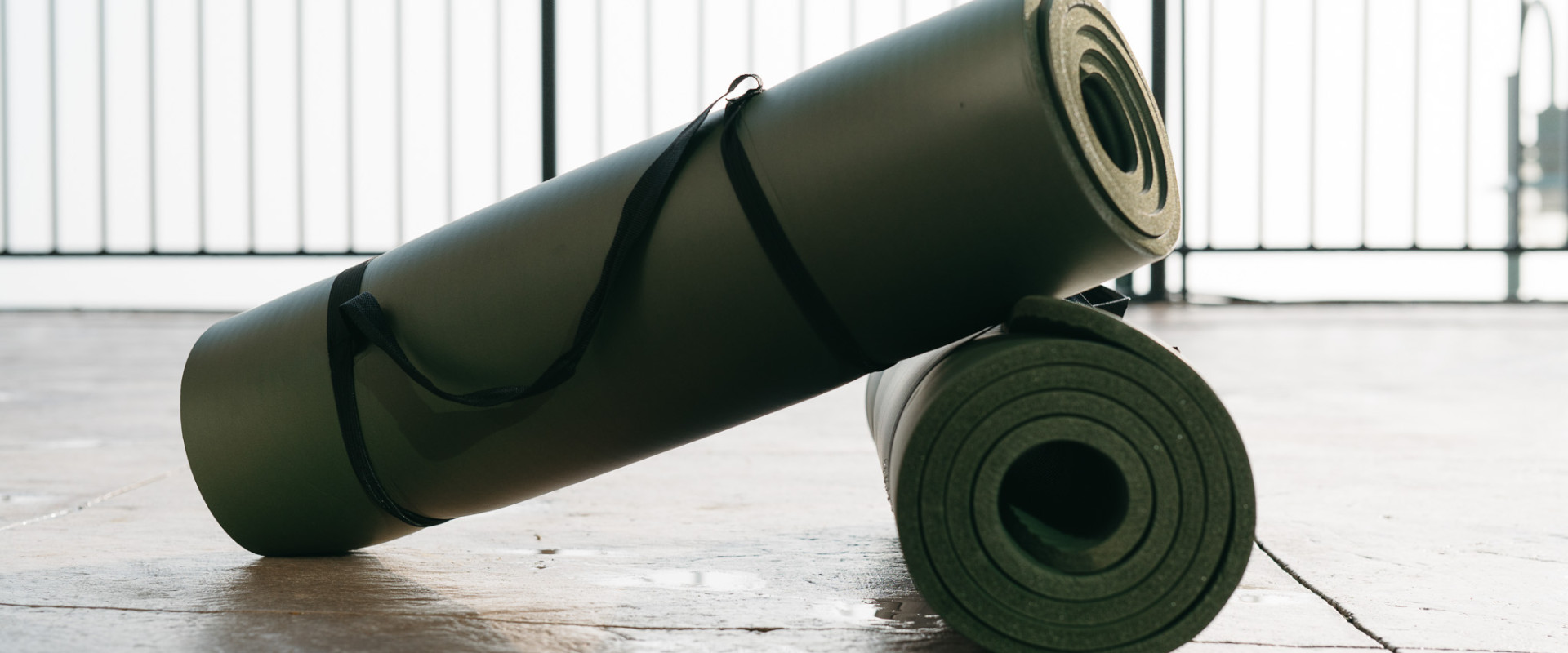 Yoga mats rolled up and situated on the patio, overlooking the waterfront