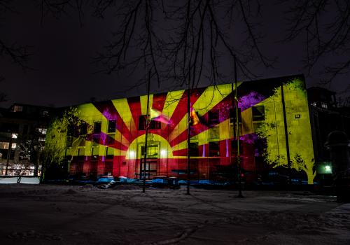 a sunset displayed on the facade of a library.