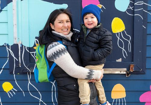 Photo of mother and child in front of a jellyfish mural
